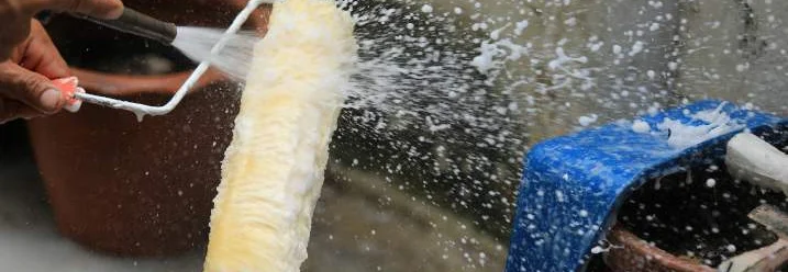 Farbrolle wird mit Wasser gereinigt